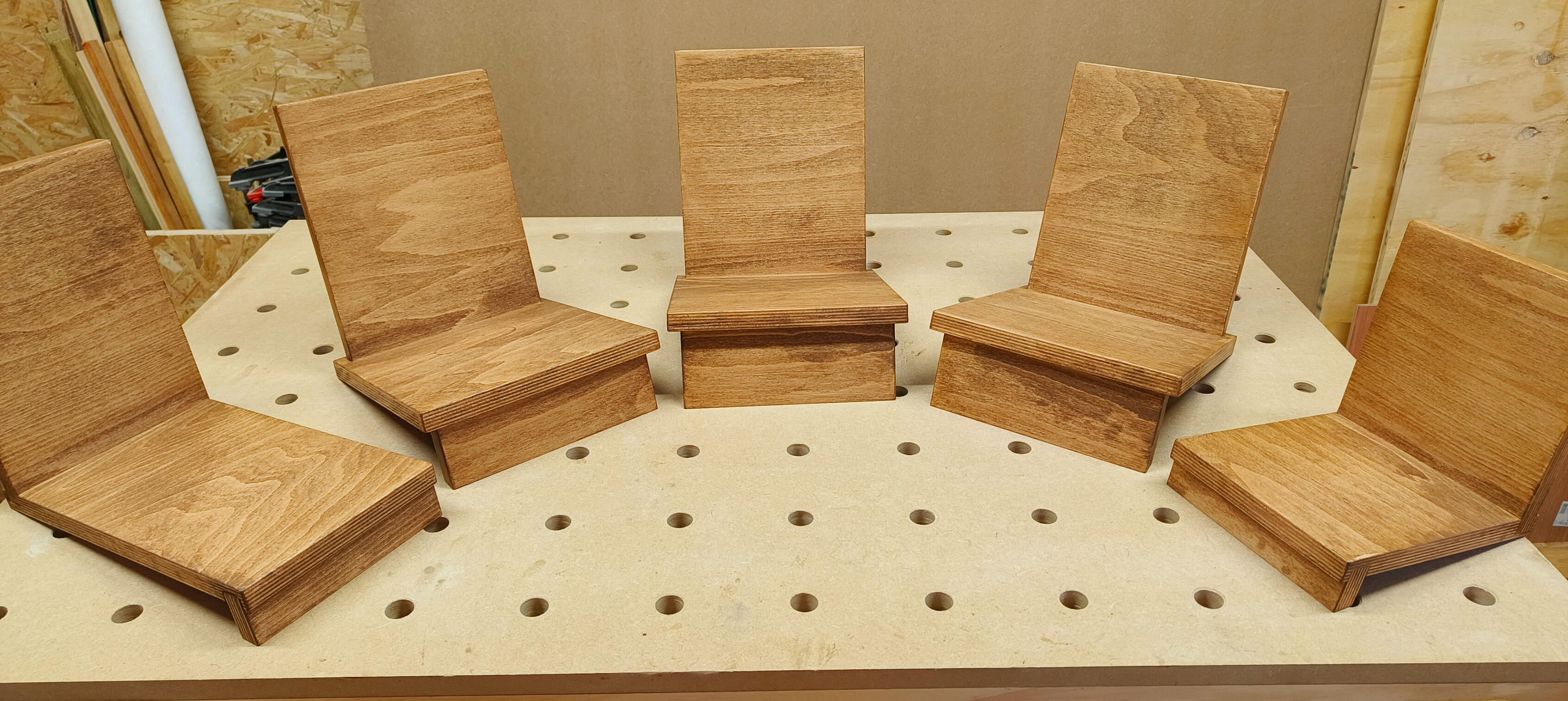 Houten boekensteunen in het atelier. Links: boekensteun (C), midden: 3x boekensteun (B), rechts: boekensteun (C)