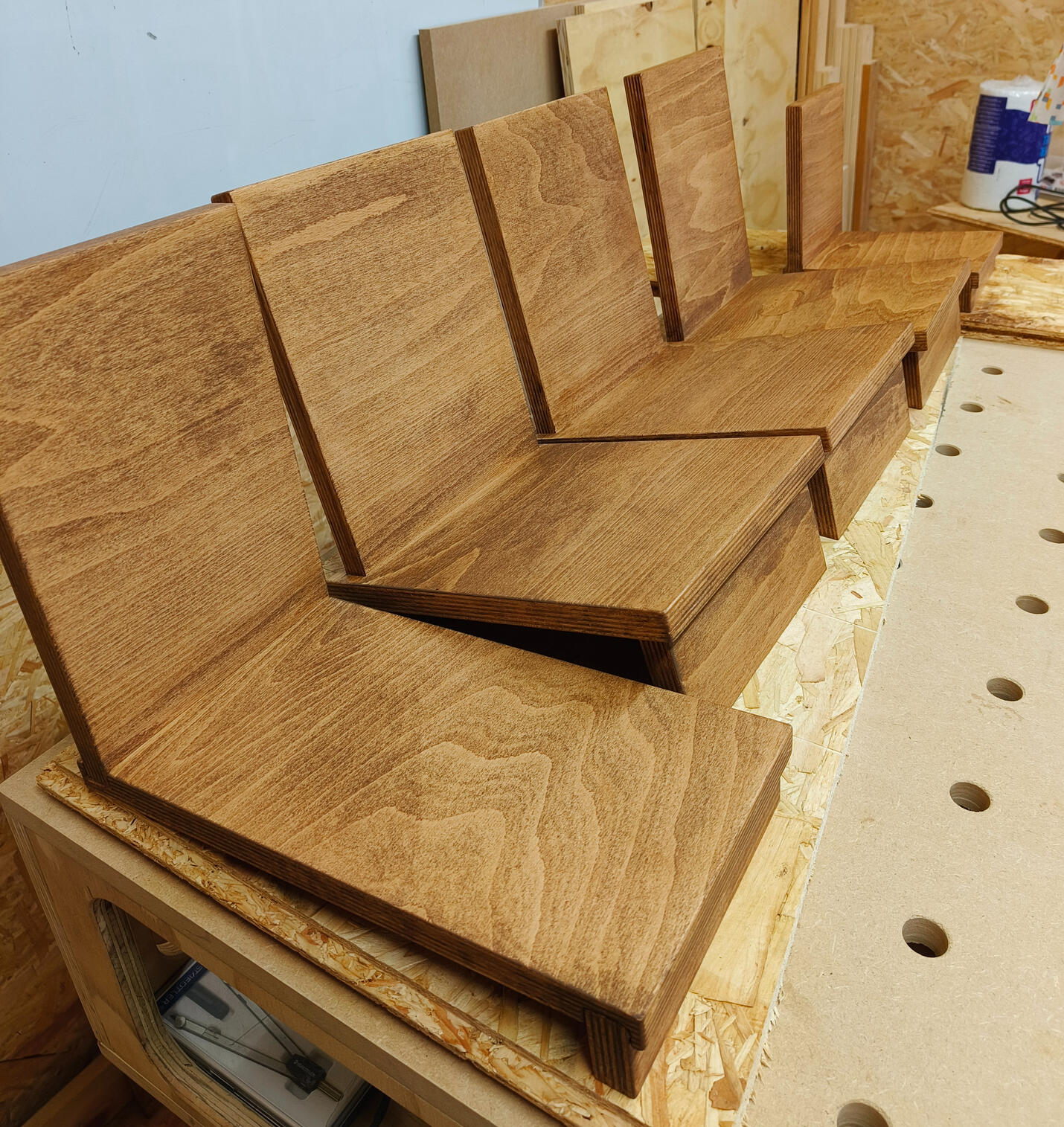 Houten boekensteunen in het atelier. Van voor naar achter: boekensteun (C), 3x (B), (A)