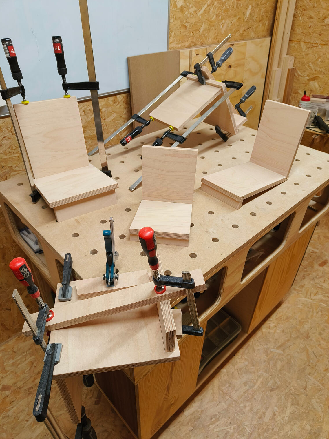 Lijmen van boekensteunen in het atelier.